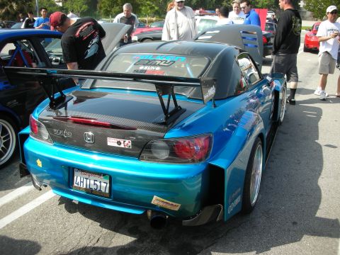 1998 Ford Crown Victoria - teal Honda S2000 shown from the rear with a tall carbon-fiber wing and California plate at a car meet.