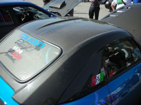 1998 Ford Crown Victoria - carbon-fiber hardtop on a teal car, its rear window covered with Falken and other sponsor decals.