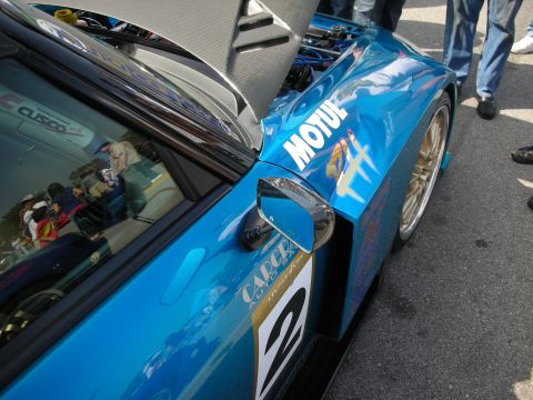 1998 Ford Crown Victoria - Detail of a blue race car's front fender showing a number 2 panel, Motul sponsor decal and side mirror.
