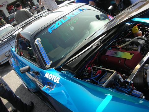 1998 Ford Crown Victoria - teal Honda S2000 with hood raised reveals a turbocharged engine, wearing Falken and Motul decals at a show.