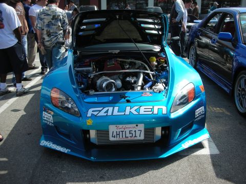 1998 Ford Crown Victoria - teal Honda S2000 shown head-on with hood raised, dominated by a large FALKEN decal across the front bumper.