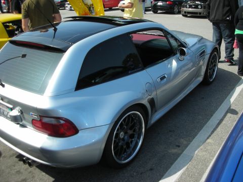 1998 Ford Crown Victoria - Rear three-quarter of a silver BMW Z3-style shooting-brake coupe on multi-spoke wheels, parked at an outdoor meet.