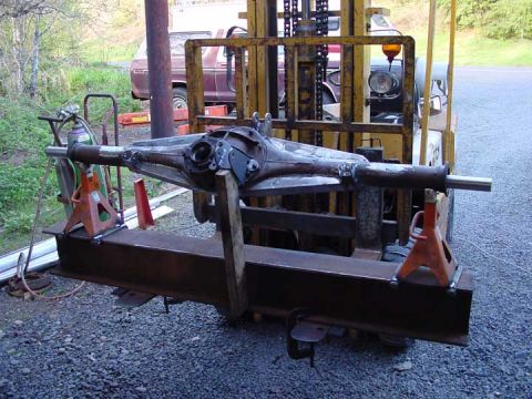 1979 Ford Bronco - Rear axle assembly being worked on, supported by jack stands and a beam.
