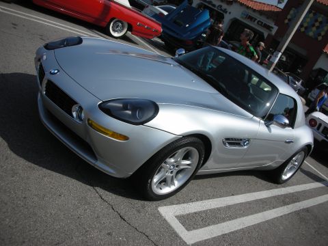 1998 Ford Crown Victoria - Silver BMW Z8-style roadster with chrome side vents and BMW badges, parked diagonally in a sunny lot at a car meet.