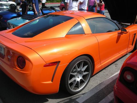 1998 Ford Crown Victoria - Side profile of an orange Callaway coupe with gray alloy wheels parked among other cars at an outdoor show.