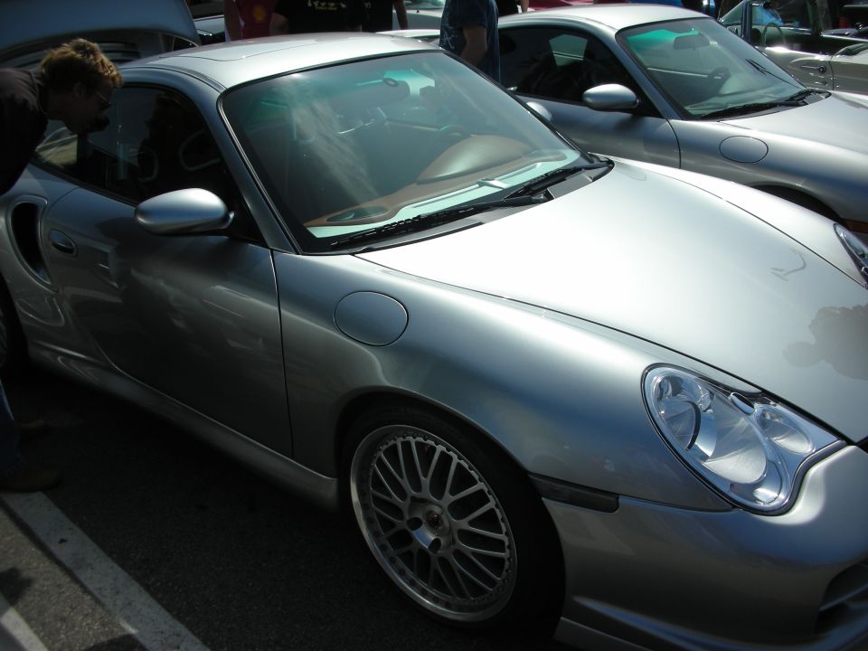 Side front view of silver Porsche 911 with multi-spoke wheels