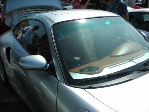 1998 Ford Crown Victoria - Close view of a silver Porsche's cabin showing tan leather seats and door panel through the side window.