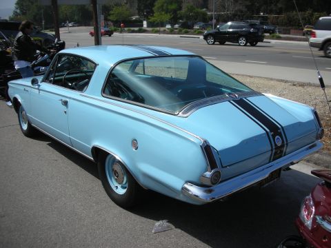 1998 Ford Crown Victoria - Rear three-quarter view of a light blue classic fastback coupe with black stripes and wraparound rear glass parked roadside.