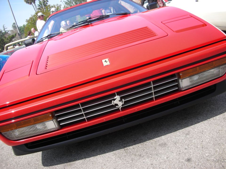 Red Ferrari front end with prancing-horse badge and pop-up headlights