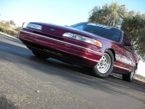 1992 Ford Crown Victoria - Maroon 1992 Ford Crown Victoria with aftermarket wheels and "EDM" banner on windshield parked on asphalt.