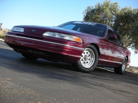 1992 Ford Crown Victoria - A maroon 1992 Ford Crown Victoria is shown with aftermarket wheels and a lowered stance.