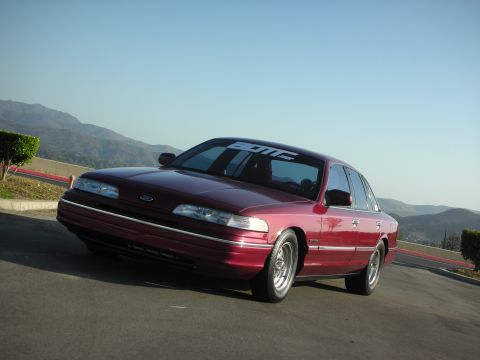 1992 Ford Crown Victoria - Maroon 1992 Ford Crown Victoria parked on an incline with mountains in the background.