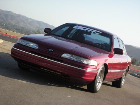 1992 Ford Crown Victoria - A maroon 1992 Ford Crown Victoria is shown from a three-quarter front angle on a sunny day.