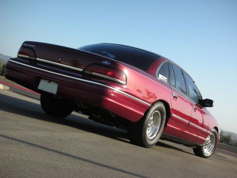 1992 Ford Crown Victoria - Maroon 1992 Ford Crown Victoria with drag tires seen from the rear 3/4 angle.