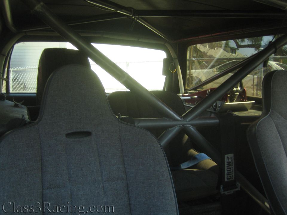 Interior of a caged race truck showing seats and roll bars