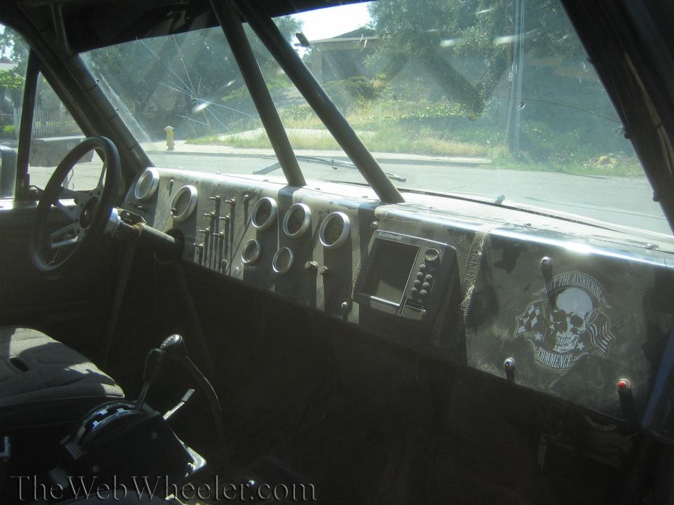 Dashboard of a race truck with gauges and a skull-decal panel