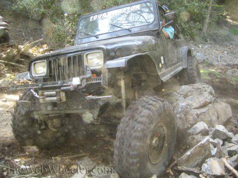 1987 Suzuki Samurai - This Jeep Wrangler is navigating a rocky trail, with another vehicle visible in the background.