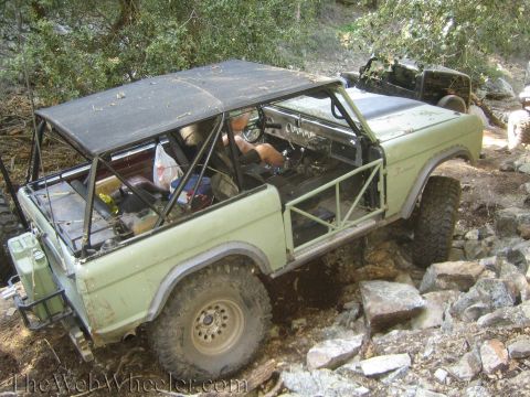 1987 Suzuki Samurai - An off-road vehicle navigates a rocky trail, with another vehicle visible in the background.