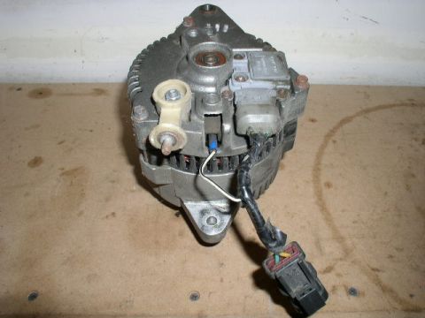 1996 Ford Probe - This is an alternator, a component of a vehicle's electrical system, shown with its wiring harness.