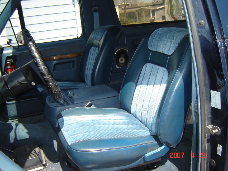 1988 Ford Bronco interior showing blue cloth and vinyl seats, steering wheel, and center console