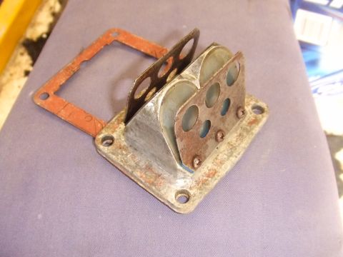1995 Ford Mustang - Reed valve assembly with gasket, likely for a small engine or motorcycle.