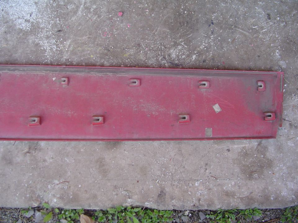 Red car trim piece with multiple U-shaped clips on the underside