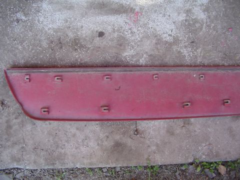 1994 Ford Probe - Red plastic trim piece with mounting clips, likely from a car's exterior.