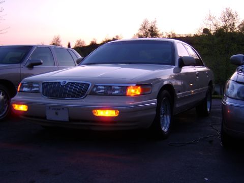 1996 Mercury Grand Marquis - A 1996 Mercury Grand Marquis is seen from the front at dusk, parked next to another vehicle.