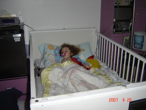 1993 Ford Bronco - A child rests in a hospital bed, surrounded by medical equipment and blankets.