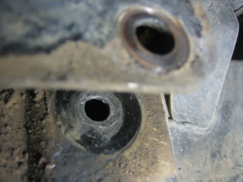 2001 Jeep Wrangler - Close-up of a rusted metal bracket with bolt holes, likely part of a vehicle's undercarriage.