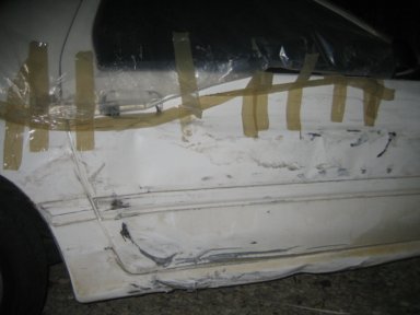 1991 Mazda RX-7 - This car door has significant damage and is crudely repaired with tape.