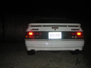 1991 Mazda RX-7 - Rear view of a 1991 Mazda RX-7 showing taillights, spoiler, and license plate UXD-49B.