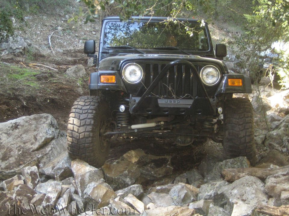 Black Jeep Wrangler on rocky terrain, front view