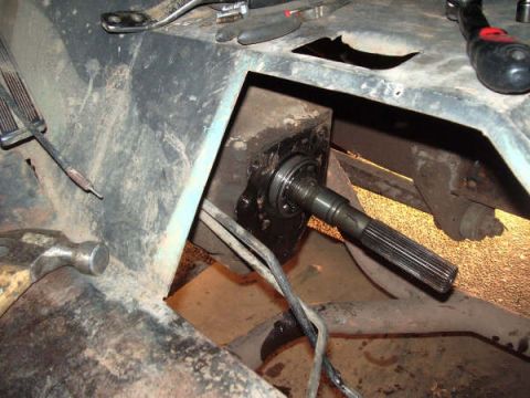 1968 Ford Bronco - Close-up view of a vehicle's driveshaft and transmission tunnel, with various tools present.