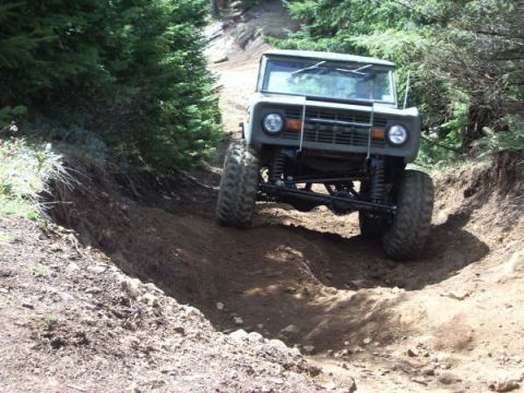 1968 Ford Bronco - This 1968 Ford Bronco navigates a challenging off-road path through a wooded area.