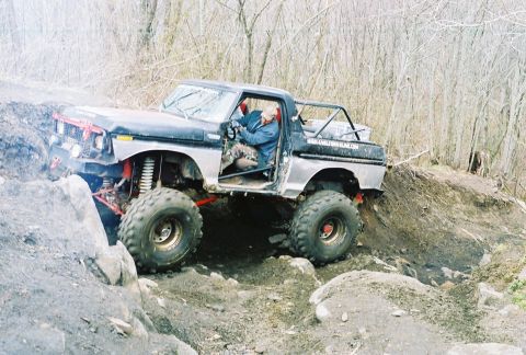 1978 Ford Bronco - A modified 1978 Ford Bronco navigates a challenging off-road course with steep inclines and large rocks.