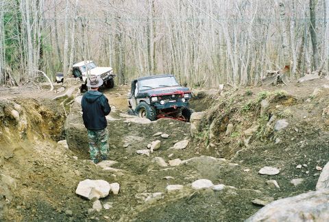 1978 Ford Bronco - Off-roading adventure in a wooded area with challenging terrain.