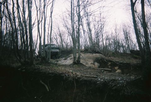 1978 Ford Bronco - A 1978 Ford Bronco navigates a challenging off-road course through a dense forest.