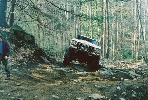 1978 Ford Bronco - An off-road vehicle navigates a wooded trail.