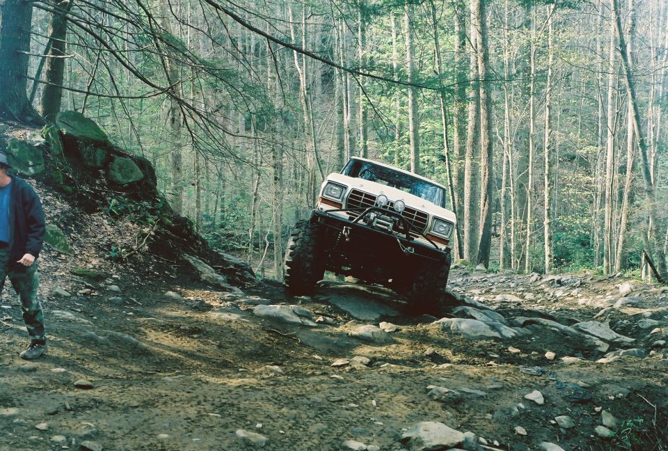 Red off-road vehicle with white top on a dirt path