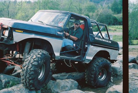 1978 Ford Bronco - This lifted 1978 Ford Bronco features oversized tires and a visible roll cage, captured in a 3/4 front view.