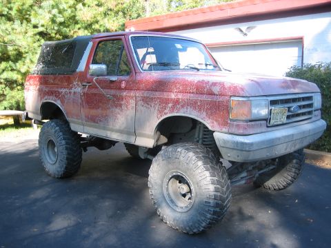 1990 Ford Bronco - This lifted 1990 Ford Bronco features large off-road tires and a red exterior.