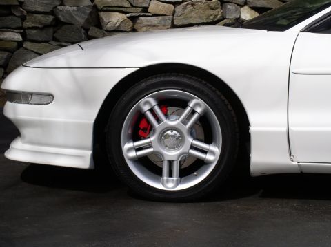 1996 Ford Probe - Close-up of the front wheel and fender of a white 1996 Ford Probe GT.