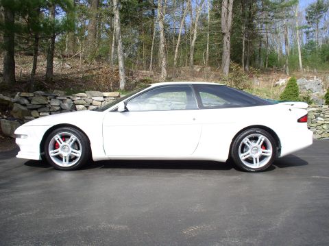 1996 Ford Probe - Side profile of a white 1996 Ford Probe GT coupe with aftermarket wheels and red brake calipers.