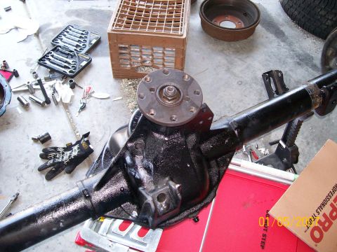 1996 Ford Bronco - A rear axle assembly is shown on the floor with various tools and parts scattered around it.