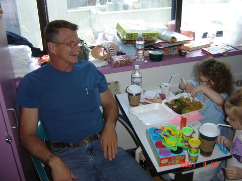 1993 Ford Bronco - A man and two children are gathered around a table, enjoying a meal together.