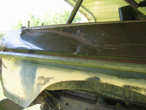 1992 Ford Mustang - Close-up of a damaged vehicle body panel, showing wear and tear on the exterior.