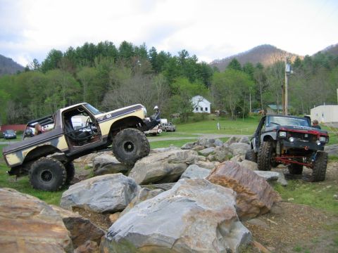 1992 Ford Mustang - Modified trucks tackle a rocky obstacle course in a rural setting.