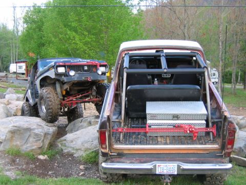 1992 Ford Mustang - Modified trucks tackle a challenging rocky obstacle course during an outdoor event.