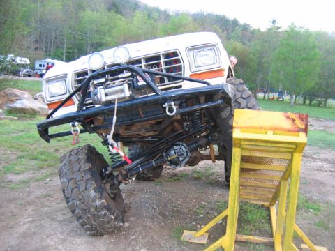 1992 Ford Mustang - Modified off-road truck with a winch and large tires is positioned near a yellow ramp.